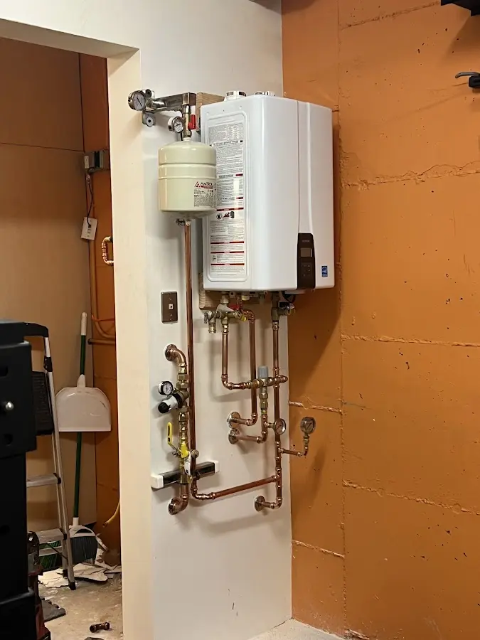 Plumbing technician inspecting water heater connections in Cromwell
